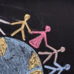chalk people holding hands around a globe